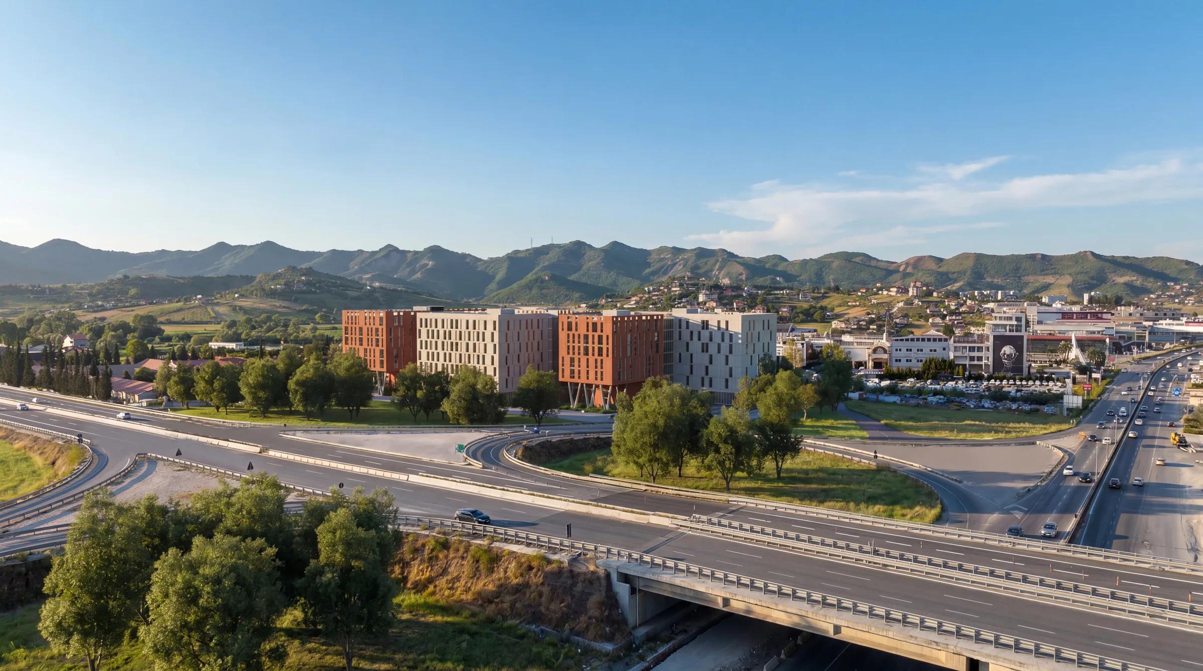 Aerial drone view of Tirana Central Park — mixed-use residential towers beside the highway near Tirana, with mountains in the background