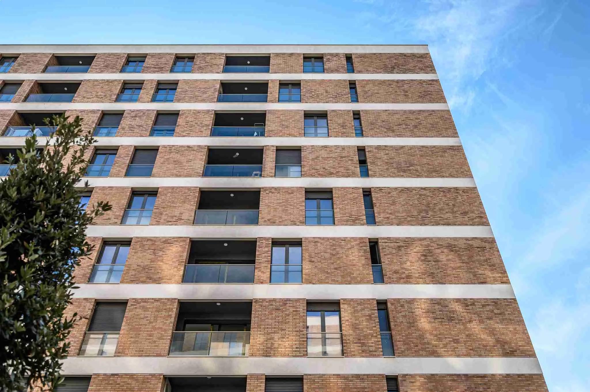 Looking up the brick facade and its recessed balconies