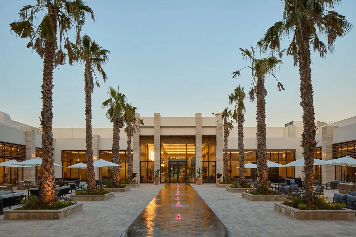 The resort's palm-lined arrival court and reflecting pool