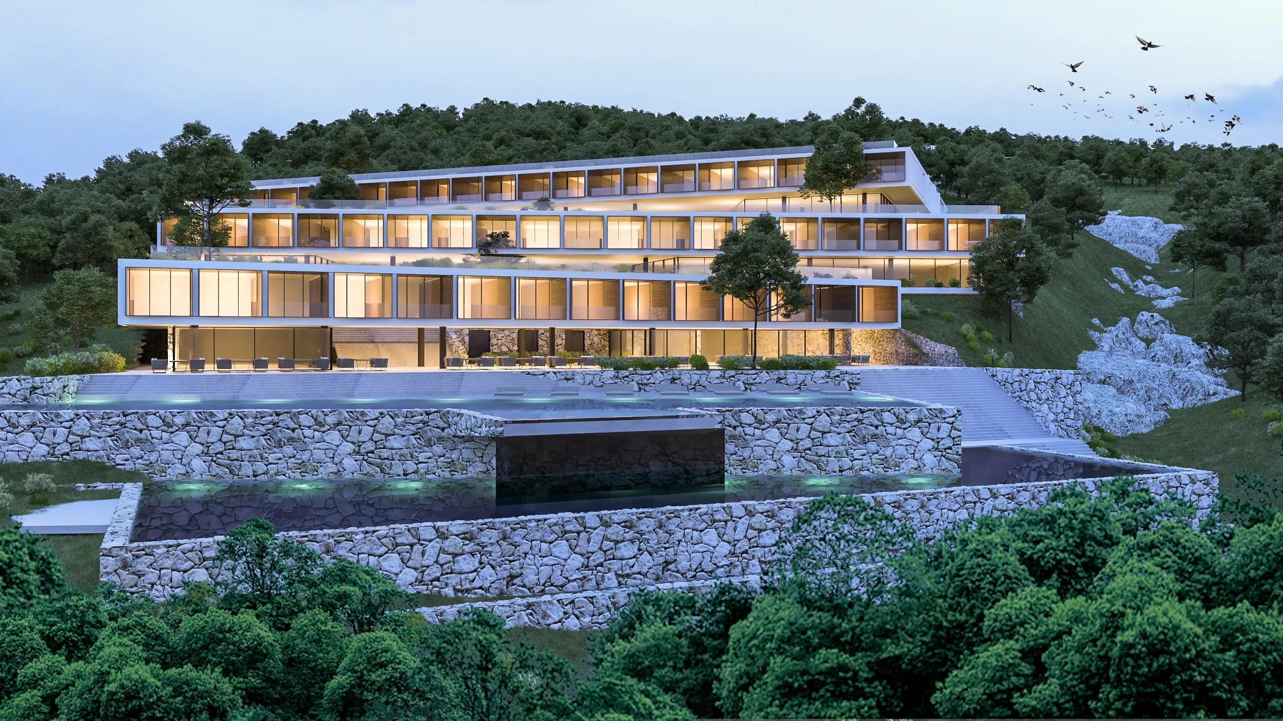 The hotel wing set into the hillside, lit at dusk