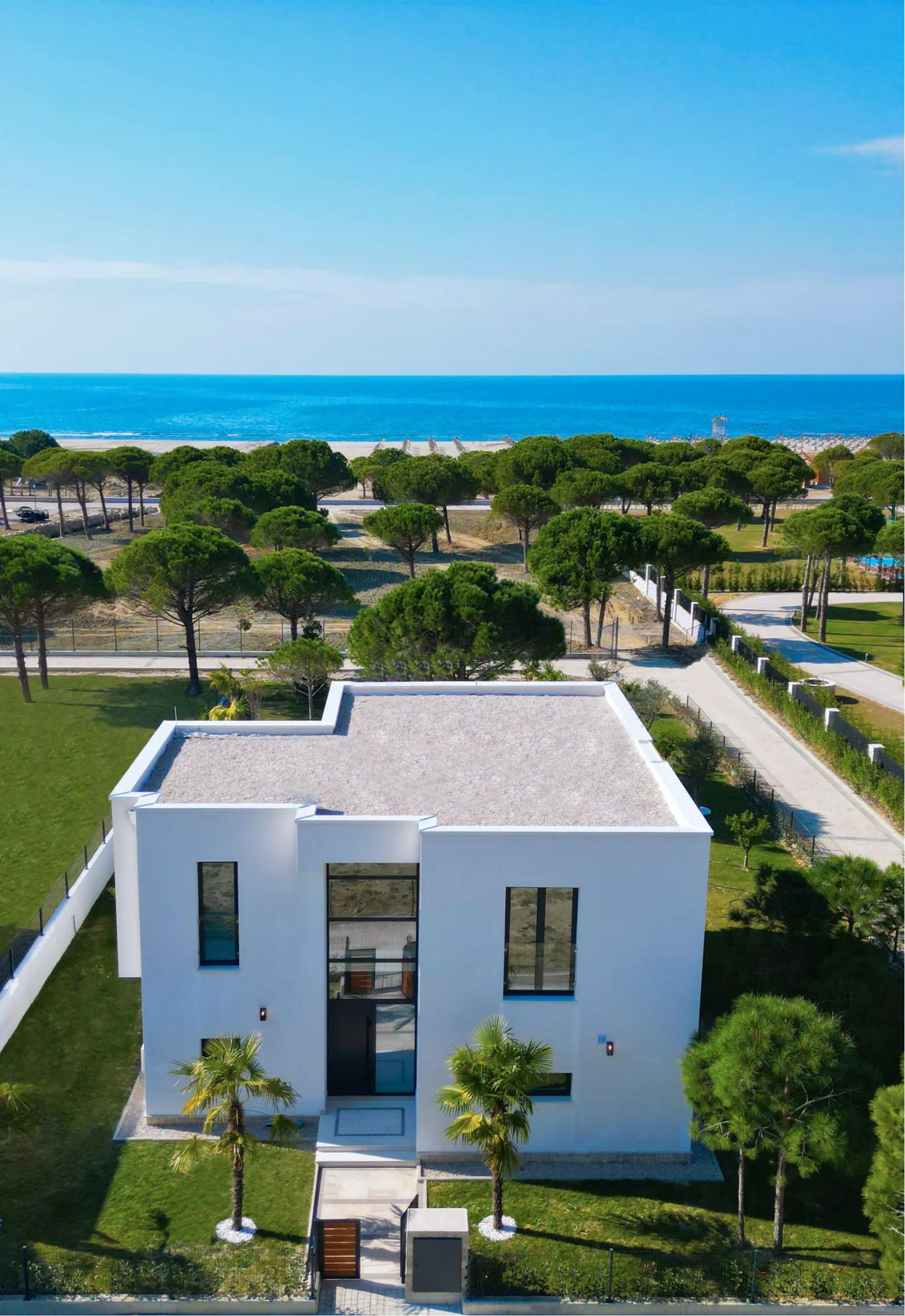 Aerial view of a beachfront villa with the sea beyond