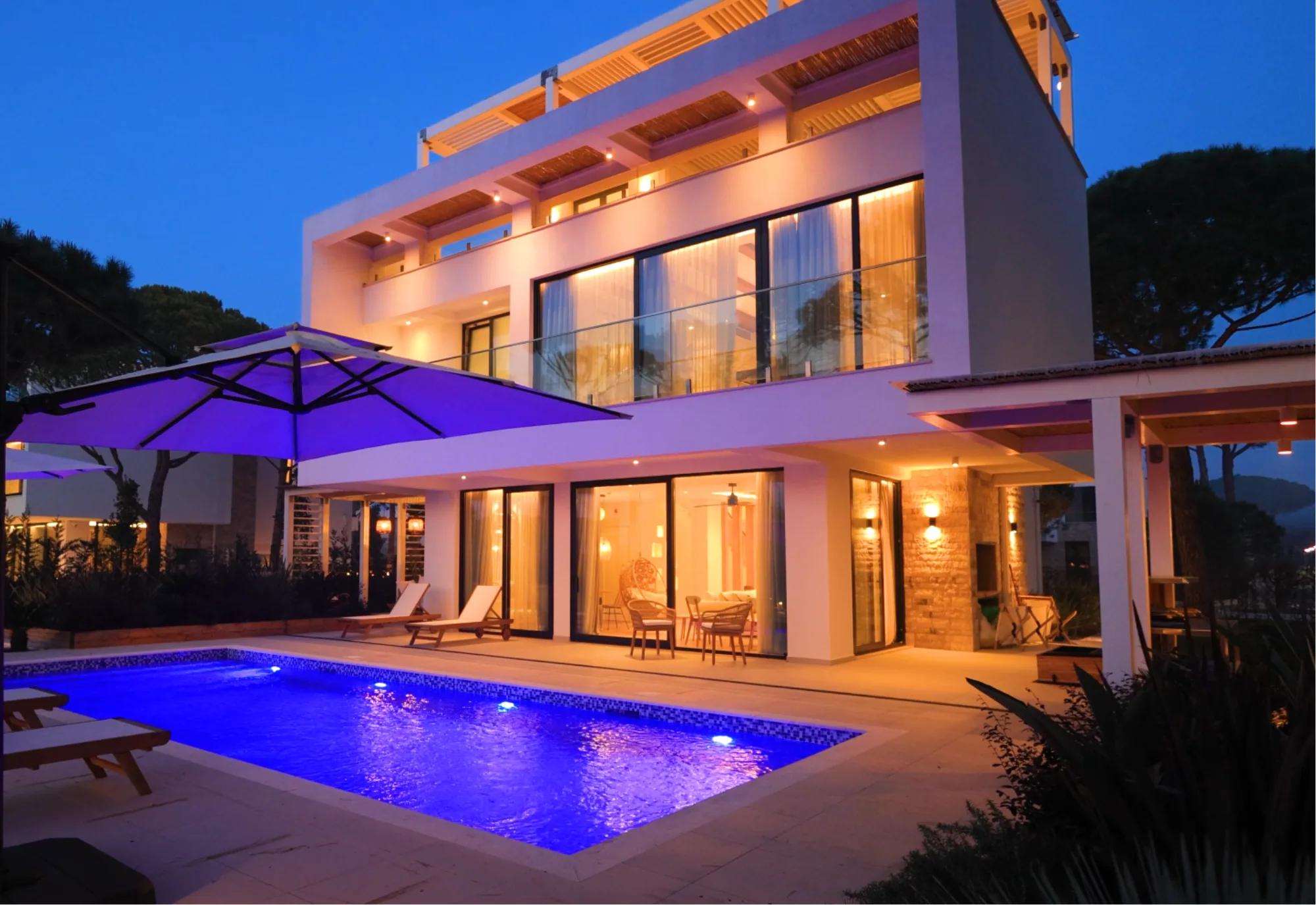 A villa's pool terrace lit at night