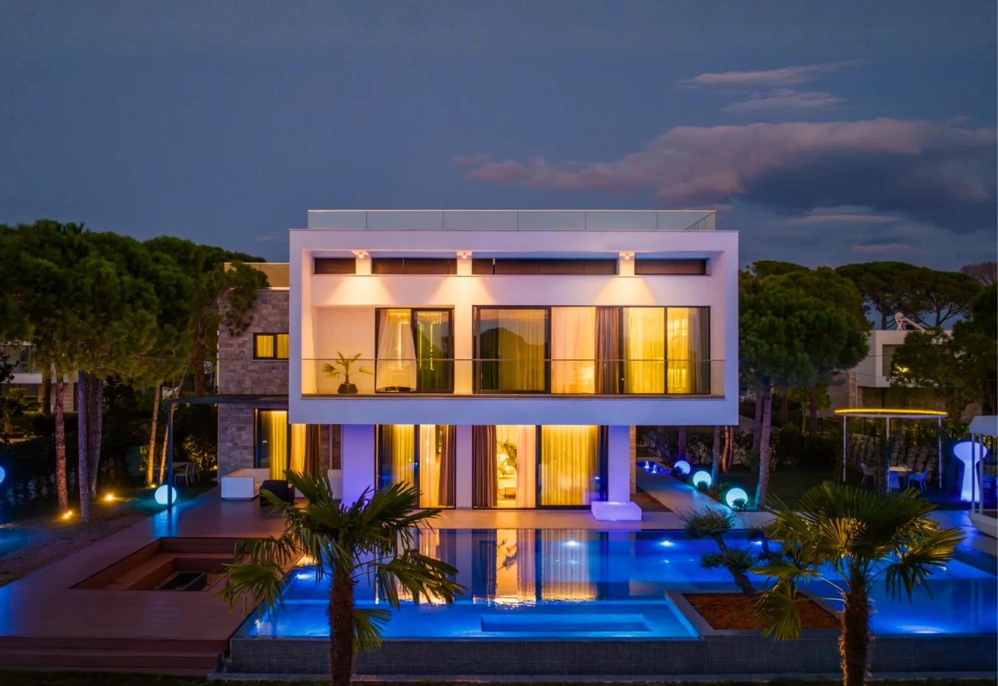 A villa and its illuminated pool at night