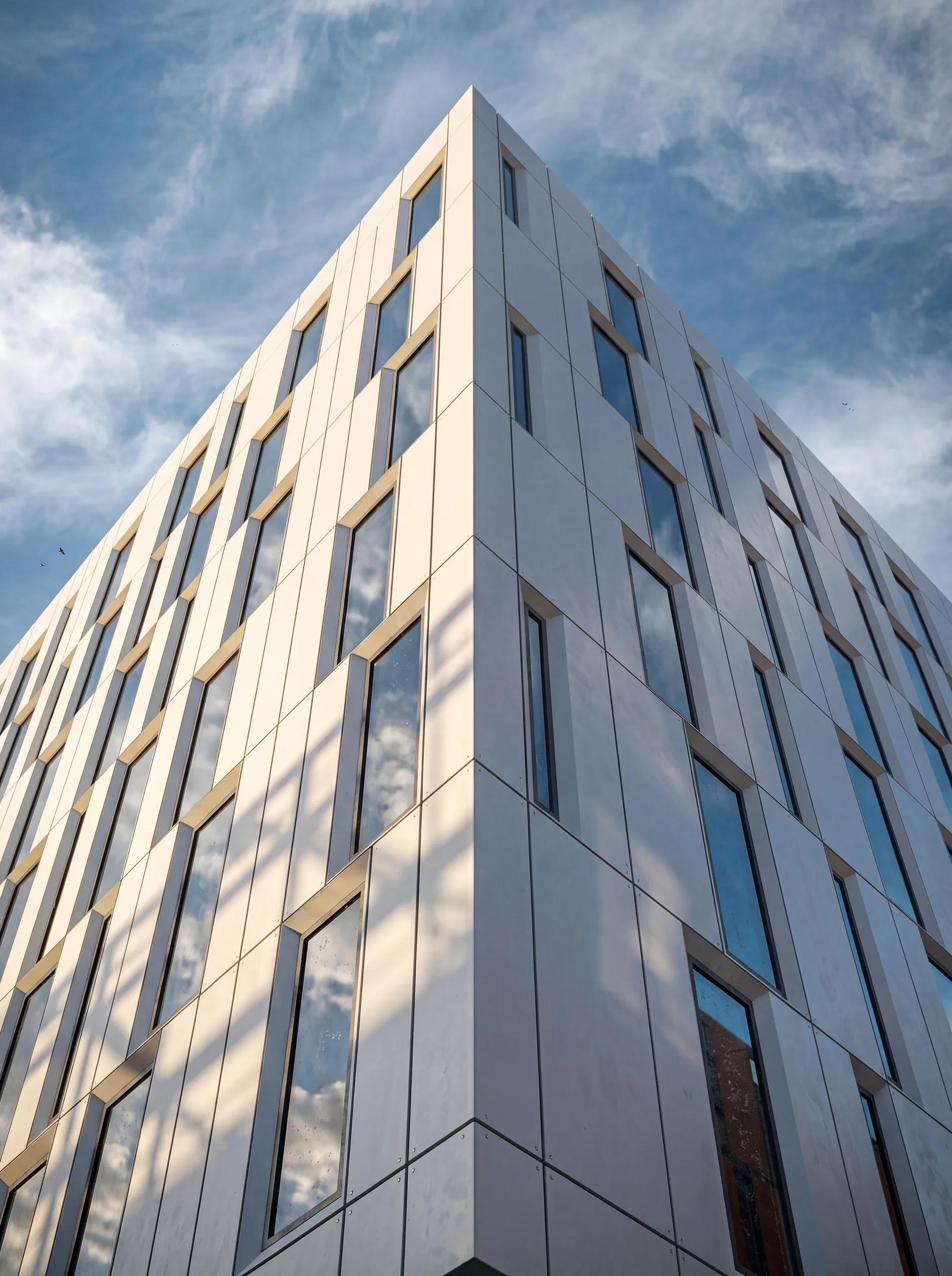 The white perforated facade rising against an open sky